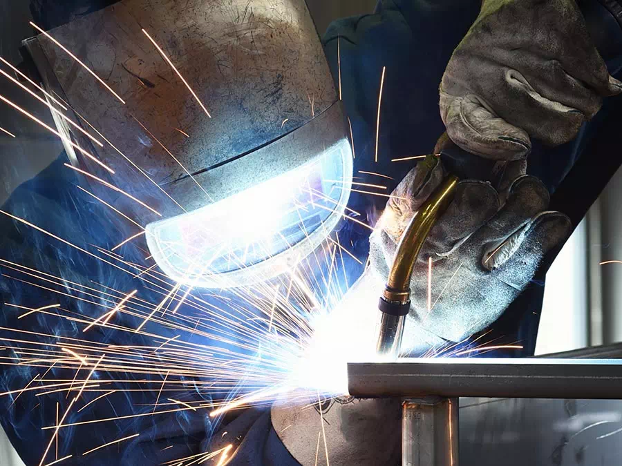 Operaio fa saldatura a filo su pezzo metallico Brescia