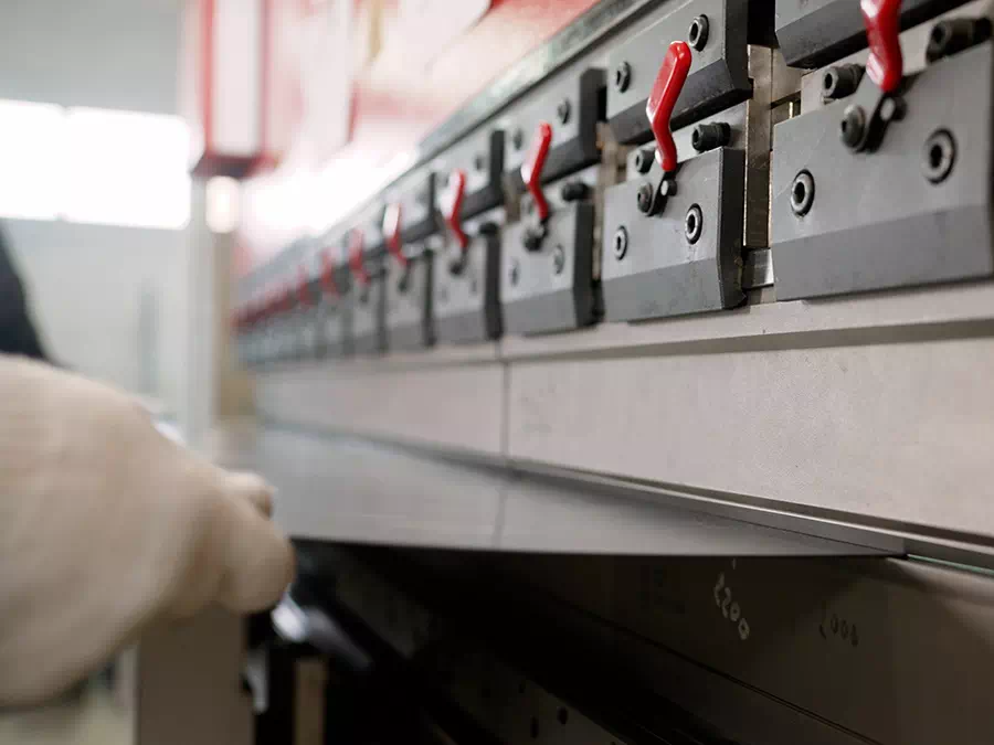 Piegatura pezzo metallico in preparazione all’assemblaggio Brescia