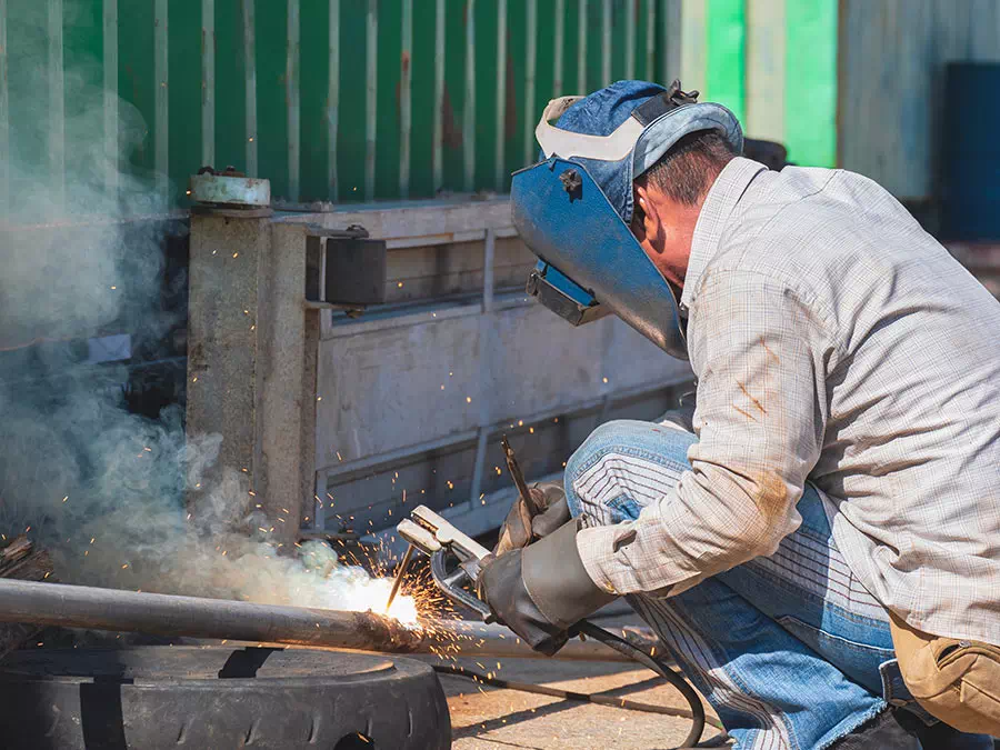 Saldatore lavora un pezzo di carpenteria metallica leggera Mantova